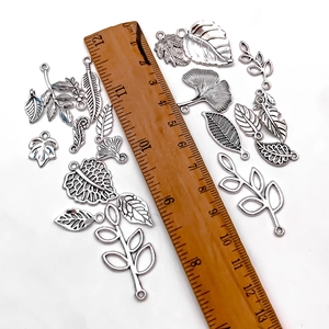 Antique silver leaf pendants set in various styles with ruler for size measurement