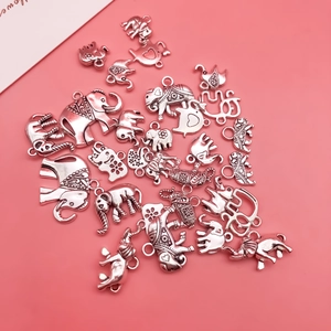 Détails de breloques éléphant en argent antique pour création de bijoux sur fond rose
