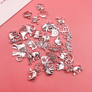 Gros plan détaillé de divers pendentifs éléphants en argent antique pour bijoux DIY