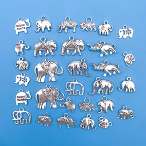 Détail macro de 25 pendentifs éléphants argentés avec motifs vintage et gravure porte-bonheur