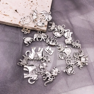 Détail macro de breloques éléphants en argent antique avec gravure fine buena suerte