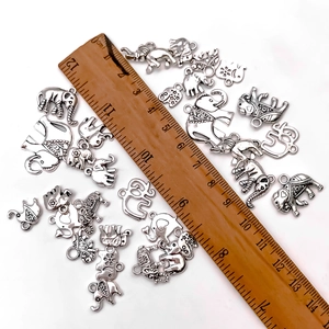 Pendentifs éléphant en argent tibétain pour bijoux DIY avec règle sur fond blanc