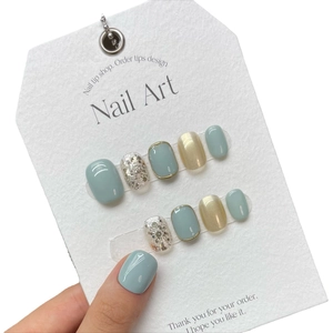 Handmade press-on nails in mint green and champagne glitter on a display card