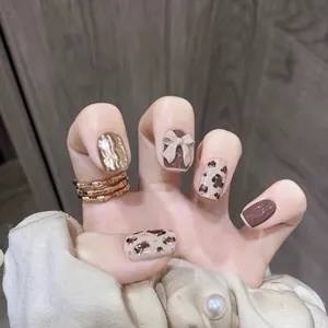 Handmade press-on nails featuring brown leopard print and 3D bow on almond shape