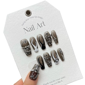 Gothic press-on nails with dark metal accessories and 3D cross charms on gray gradient base