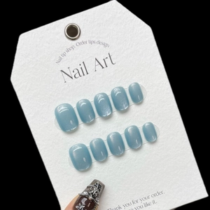 Short round blue cat eye press-on nails with shimmering ice-blue rainbow finish
