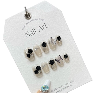 Handmade black 3D flower and butterfly press-on nails with white pearl accents on tips
