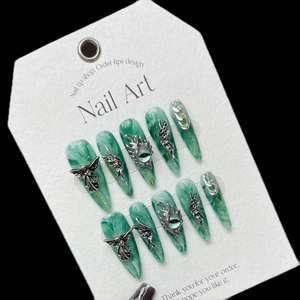 Handmade long almond press-on nails with green marble texture and 3D gothic silver wings