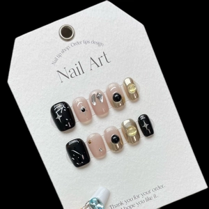 Handmade graffiti press-on nails in black and champagne gold with 3D sun heart design