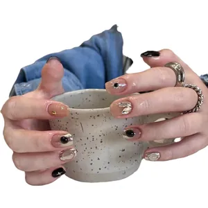 Handmade press-on nails featuring black starburst patterns, nude rhinestones and mirror finish