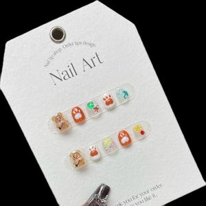 Cartoon style children press-on nails with 3D brown bear and star motifs in orange and white