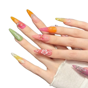 Colorful stiletto press-on nails with floral 3D patterns and rhinestones on white background