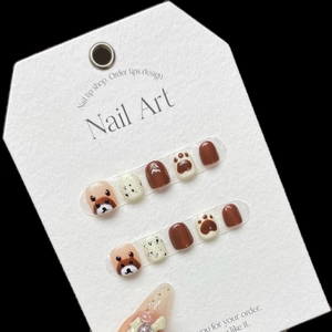 Short round press-on nails for kids featuring brown cartoon bear and paw print designs