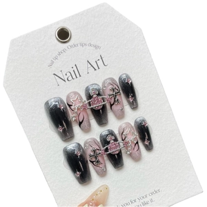 Handmade press-on nails featuring glittery pink planet charms and black flame cat-eye designs