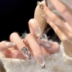 Handmade champagne cat eye press-on nails with silver French tips and rhinestone charms