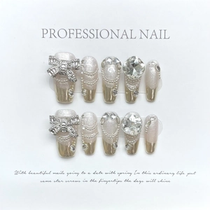 Faux ongles faits main de luxe avec paillettes champagne, french argent et nœud 3D