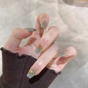 Gray-green gradient press-on nails in long coffin shape with gold textured accents