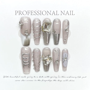 Handmade press-on nails with silver glitter, rhinestones, and star charms in pink finish