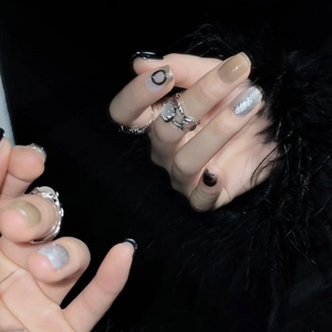 Minimalist black and silver gradient press-on nails with creative silver rings on dark background