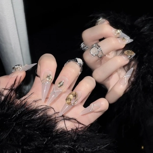 Luxurious champagne gold press-on nails with amber gems and silver beads on black feather