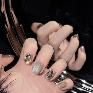 Cat eye press-on nails in milk tea and champagne tones with rhinestones on hand