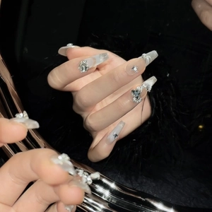 Sparkly nude coffin press-on nails with silver glitter, rhinestones and butterfly bows