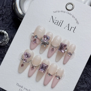 Handmade almond press-on nails featuring pink rhinestones, bows and delicate steel chains