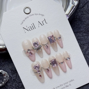 Handmade press-on nails with pink heart crystals and silver bow on nude base