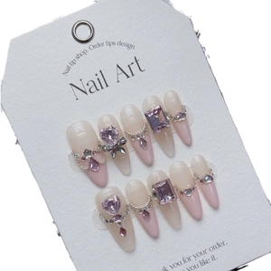 Handmade press-on nails with pink heart rhinestones, pearls, and silver bows on French tips