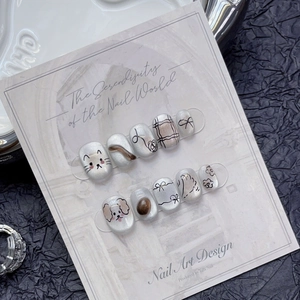 Cat eye press-on nails with cute hand-painted dog and cat art designs on ceramic tray