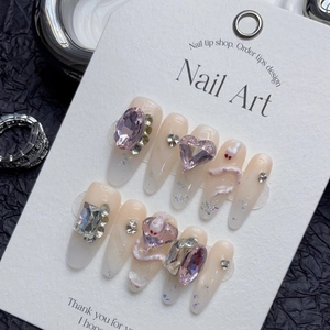Faux ongles faits main avec serpents roses et cristaux en forme d'amande longue