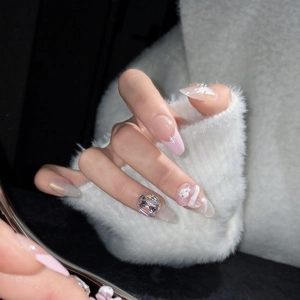 Pink French Aurora press-on nails with 3D gems and cute character on long almond shape