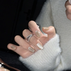 Short cat-eye press-on nails in champagne gold with a layered silver rhinestone ring