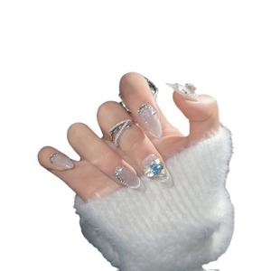 Almond cat-eye press-on nails with lavender gradient, glitter, and blue heart gemstone