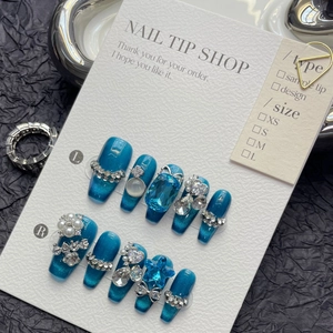 Macro detail of royal blue cat-eye press-on nails with luxury rhinestones and LOVE charms