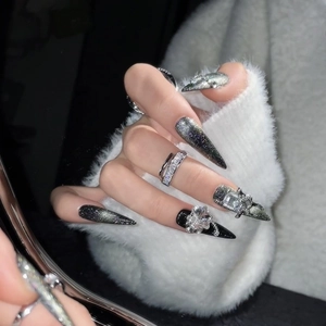 Black cat eye press-on nails in long pointed shape with 3D rhinestones and silver bows