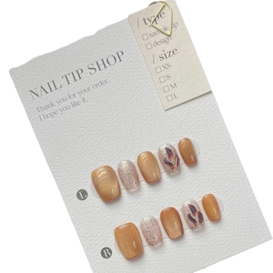 Handmade golden cat-eye press-on nails set with purple gemstones and glitter accents