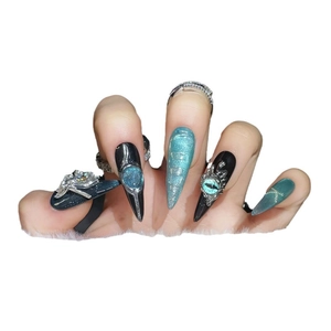 Long black press-on nails with 3D silver spiders, teal cat-eye gems, and punk design