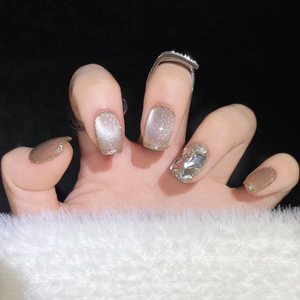 Cat eye press-on nails in champagne gold and earth tones with chunky crystal accents
