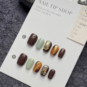 Handmade brown and green press-on nails with amber foil and rhinestones
