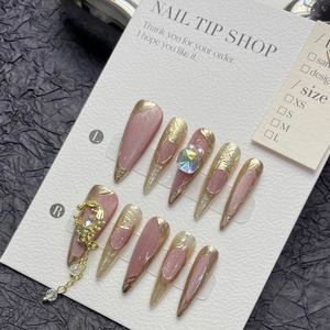 Unghie finte cat eye rosa cipria con frange dorate e accenti di strass di lusso