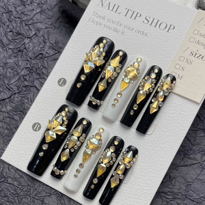 Long trapezoid black and white press-on nails with yellow rhinestones and gold studs