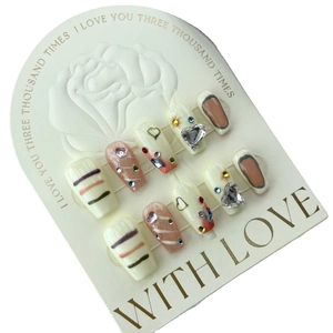 Handmade press-on nails set with graffiti art, heart charms and rhinestones on cards