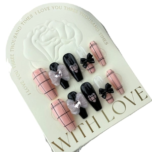 Long coffin press-on nails with pink plaid patterns and 3D black bow heart charms