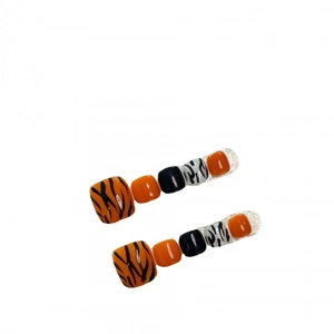 Handmade pumpkin orange and zebra print press-on toenails with glossy finish
