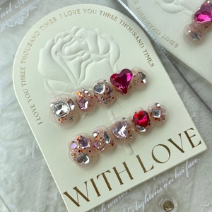 Sparkling pink heart press-on nails with star sequins on a white rose relief card