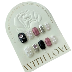Faux ongles à carreaux rose et noir avec cœurs argentés et accents de perles