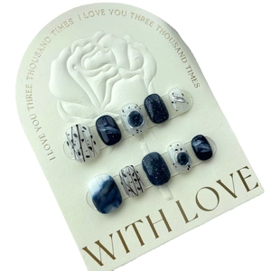 Short press-on nails in navy blue marble and glitter design on a floral gift card