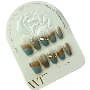 Caramel marble press-on nails with glitter accents and golden charm details