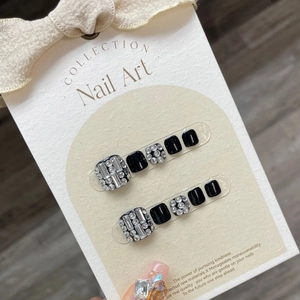 Black press-on toenails set featuring luxury rhinestones on an elegant display card
